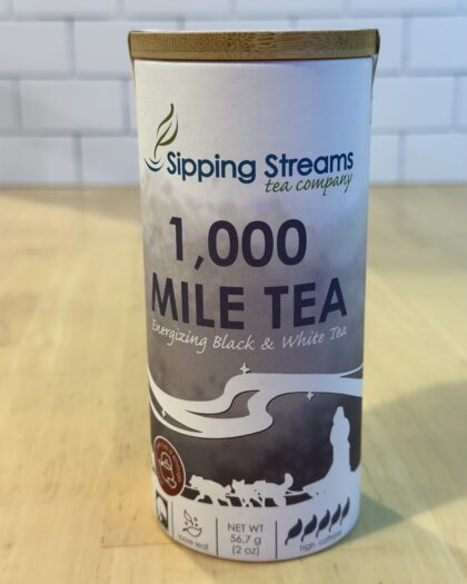 A tall retail tin filled with Yukon Quest 1000 Mile Tea, a robust blend of black and white teas inspired by Alaska’s iconic 1,000-mile race.