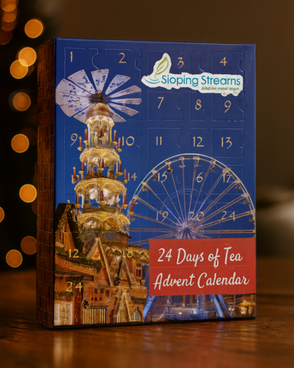 A decorative Tea Advent Calendar with 24 numbered compartments, each holding a Sipping Streams pyramid tea sachet—featuring herbal, green, black, oolong, and seasonal blends.