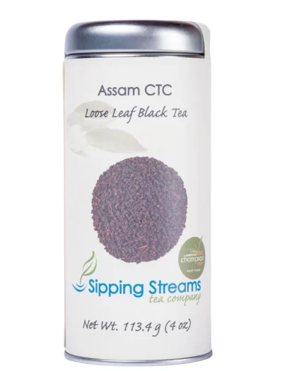 A 4 oz tall tin of Assam CTC loose leaf black tea from Sipping Streams Tea Company, labeled with a circular image of the tea granules and tea competition award seal.