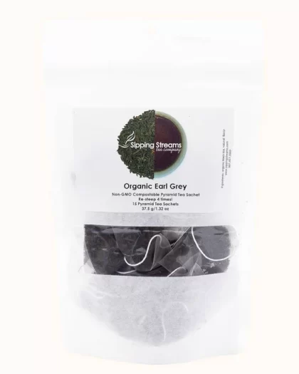 A clear, resealable bag containing 15 pyramid sachets of Sipping Streams Tea Company's Earl Grey. The label showcases the natural tea blend and promotes the non-GMO, compostable packaging, along with the re-steepable feature for an enhanced tea experience.