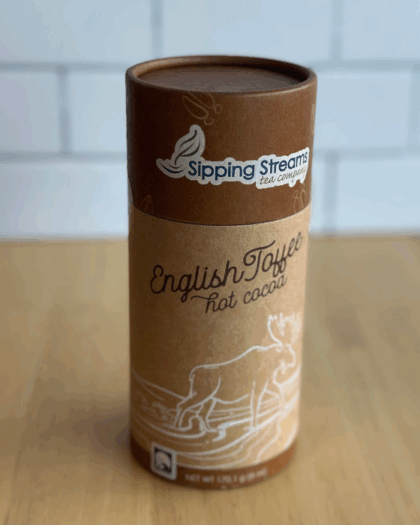 An 8 oz canister of English Toffee Hot Chocolate from Sipping Streams Tea Company, filled with a smooth cocoa mix enhanced by the rich sweetness of English toffee.