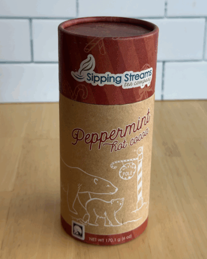 An 8 oz canister of Peppermint Hot Chocolate from Sipping Streams Tea Company, filled with a rich cocoa mix enhanced by refreshing peppermint for a festive and cozy drink.