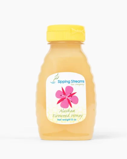 An 8 oz plastic squeeze bottle of Alaskan Fireweed Honey from Sipping Streams Tea Company. The label includes a pink fireweed flower and honeycomb design, showcasing the golden honey inside.