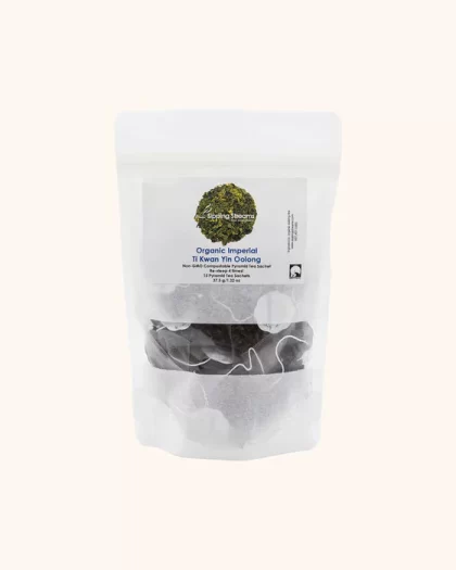 A clear, resealable bag containing 15 pyramid sachets of Sipping Streams Tea Company's Imperial Ti Kwan Yin Oolong tea. The label displays the premium oolong tea blend and emphasizes the non-GMO, compostable packaging, along with the re-steepable feature for a rich and aromatic tea experience.