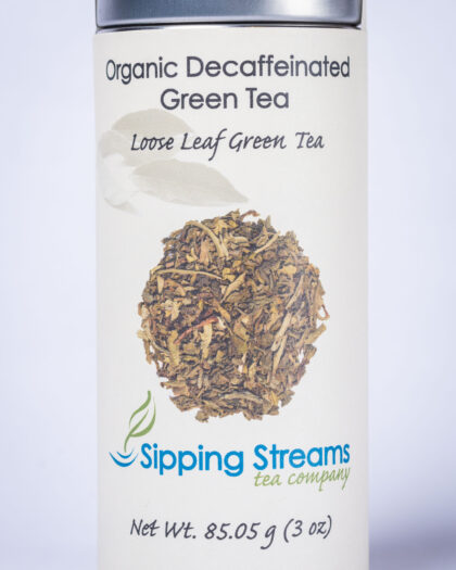A tall retail tin filled with Organic Decaffeinated Green Tea, featuring loose leaf green tea that delivers clean flavor without the caffeine.