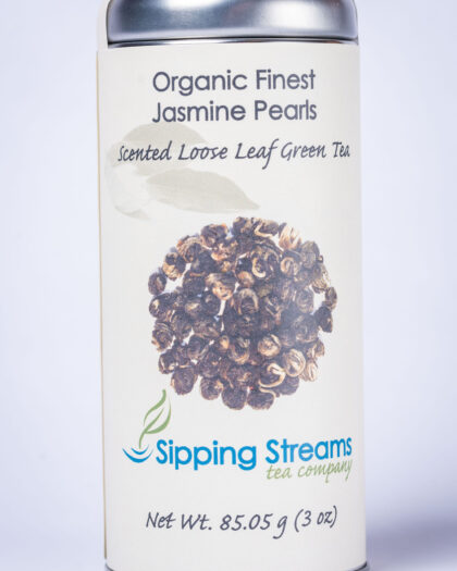 A tall retail tin filled with Organic Jasmine Pearls green tea, featuring hand-rolled pearls that unfurl during steeping and release a smooth jasmine aroma.