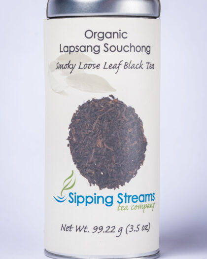 A tall retail tin filled with Organic Lapsang Souchong black tea, featuring dark leaves infused with natural pinewood smoke for a bold, distinctive flavor.