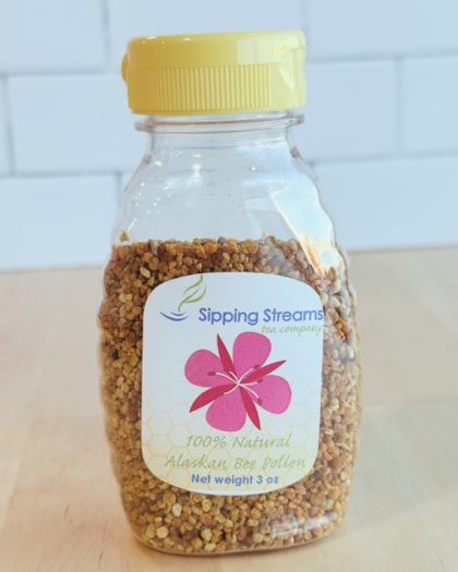 A 3 oz bottle of Sipping Streams Tea Company's Alaskan Bee Pollen, featuring golden granules in a clear plastic container with a yellow cap. The label highlights its 100% natural and nutrient-dense properties, sourced from Alaskan wildflowers for a premium health supplement.