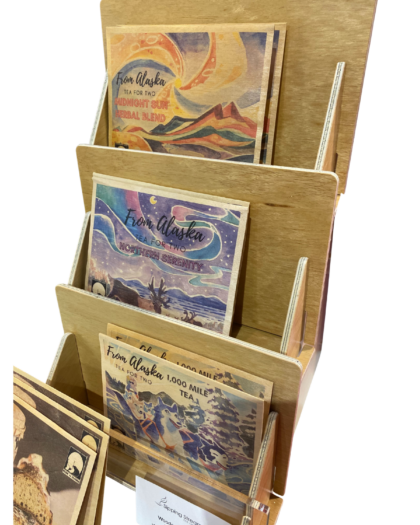 A 3-tier postcard display rack with three slanted shelves for holding wooden postcards upright. Suitable for retail counters, markets, gift shops, and boutiques.